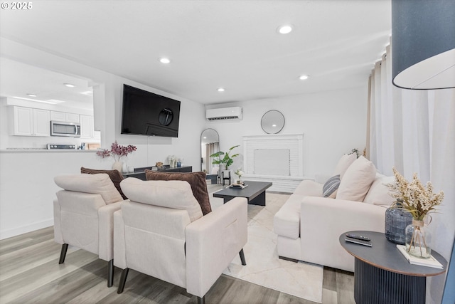 living area with light wood finished floors, recessed lighting, and a wall mounted AC