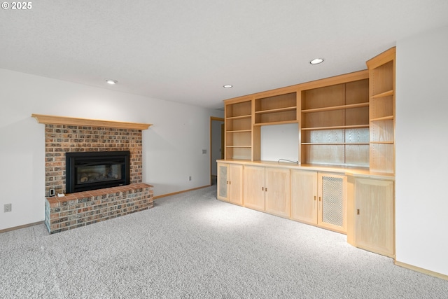 unfurnished living room featuring light colored carpet and a brick fireplace