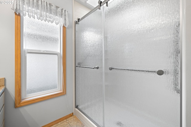 bathroom featuring tile patterned flooring, walk in shower, and vanity