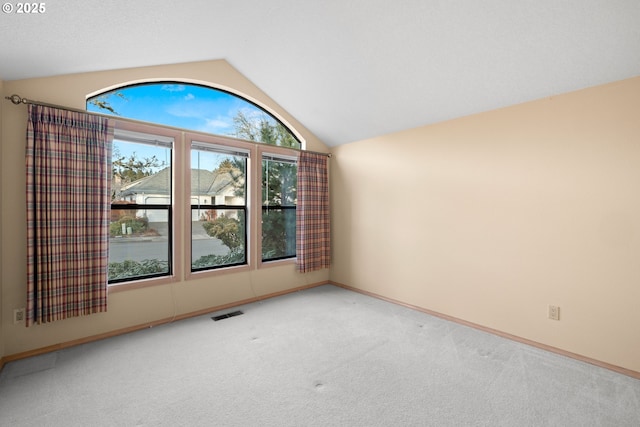 spare room featuring vaulted ceiling and carpet