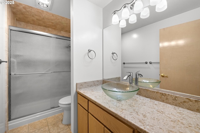 bathroom featuring vanity, toilet, a shower with shower door, and tile patterned flooring