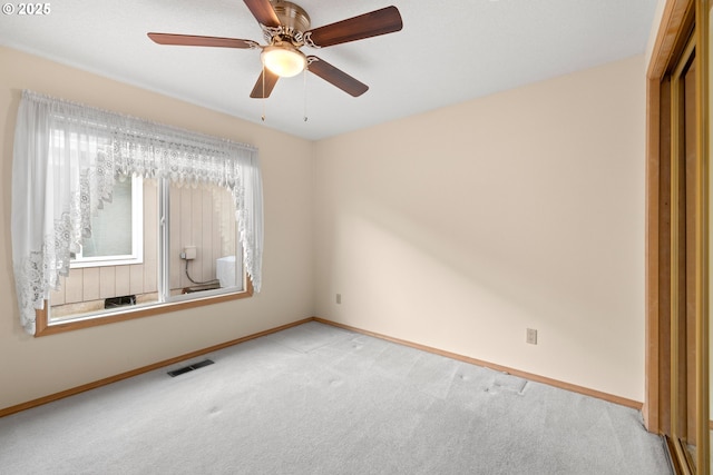 spare room with ceiling fan and light carpet