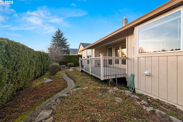 view of property exterior with a wooden deck