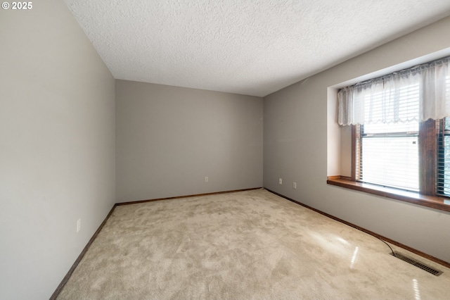 spare room with baseboards, visible vents, carpet floors, and a textured ceiling