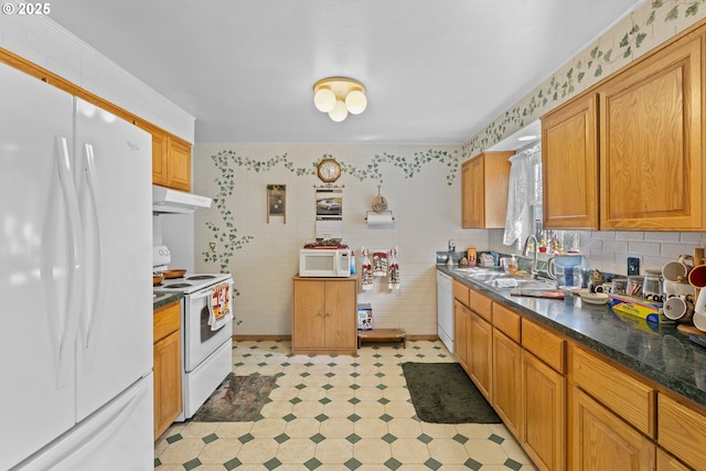 231 NE Chestnut Ave, Myrtle Creek, OR 97457 - kitchen with white appliances, dark countertops, light flooring, a sink, and under cabinet range hood