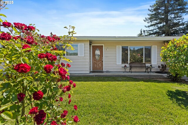 231 NE Chestnut Ave, Myrtle Creek, OR 97457 - view of front of house featuring a front yard and a patio