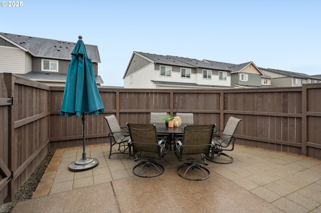 view of patio / terrace featuring a residential view, a fenced backyard, and outdoor dining space