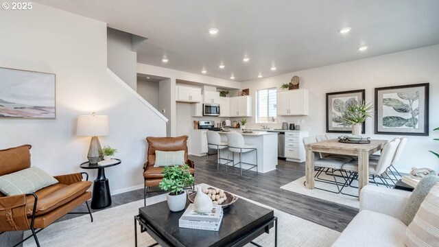 living area with recessed lighting, wood finished floors, and baseboards