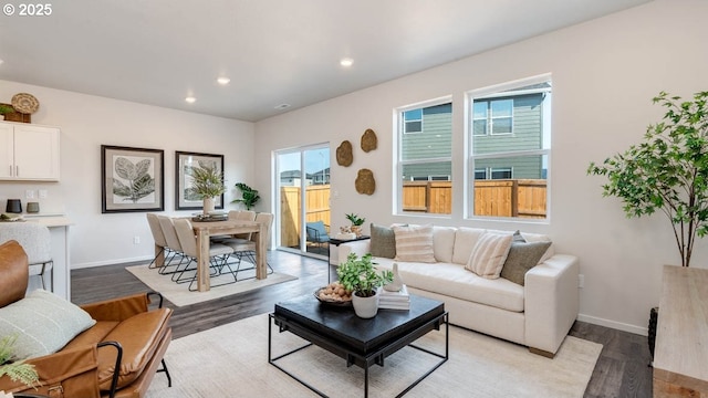 living area featuring light wood-type flooring, baseboards, and recessed lighting
