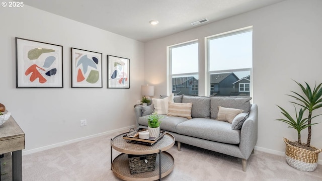 carpeted living area with baseboards