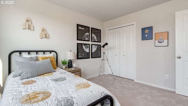carpeted bedroom featuring baseboards and a closet