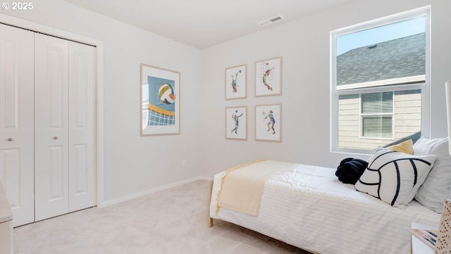 bedroom featuring carpet, multiple windows, a closet, and baseboards