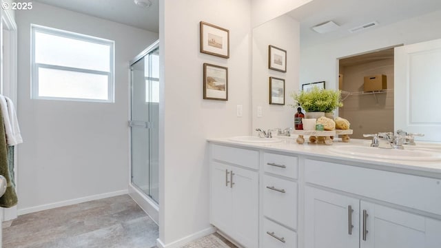 bathroom featuring a shower stall and double vanity