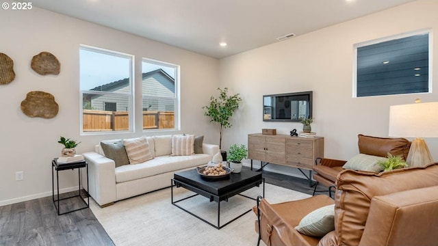 living area with light wood-style flooring, recessed lighting, and baseboards