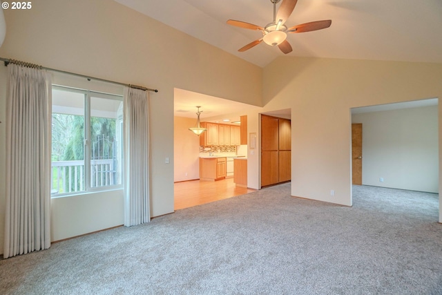 unfurnished living room featuring high vaulted ceiling, light colored carpet, and ceiling fan