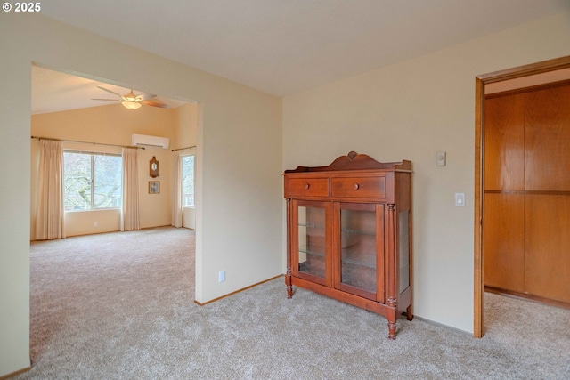 spare room with carpet, baseboards, ceiling fan, vaulted ceiling, and a wall mounted air conditioner