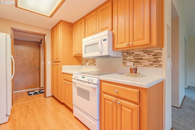 kitchen with white appliances, light countertops, tasteful backsplash, and light wood-type flooring