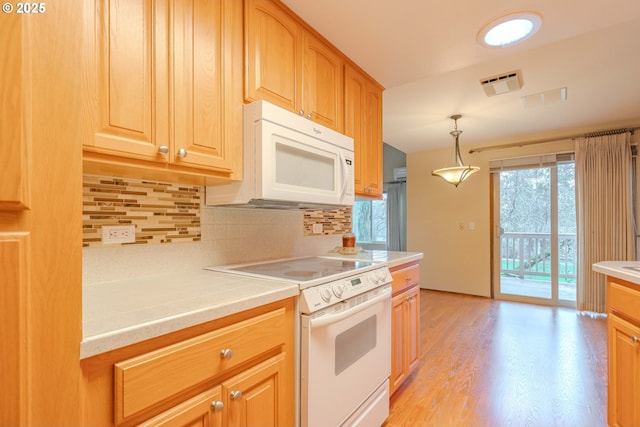 kitchen featuring decorative backsplash, white appliances, light countertops, and visible vents