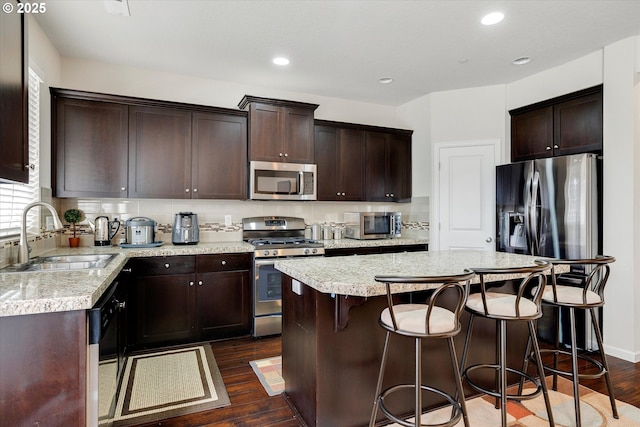 kitchen featuring a kitchen island, appliances with stainless steel finishes, sink, and dark hardwood / wood-style floors