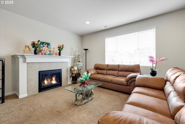 carpeted living room featuring a tiled fireplace