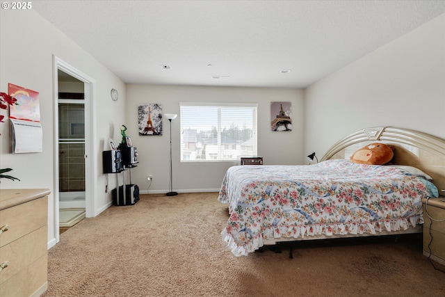 bedroom featuring light colored carpet and ensuite bath