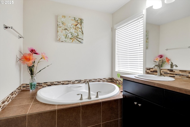 bathroom featuring vanity, tiled bath, and backsplash