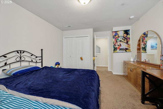 bedroom with light colored carpet, a textured ceiling, and a closet