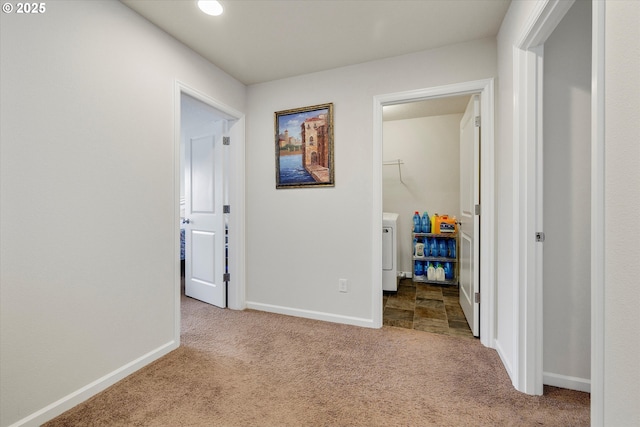 hallway featuring separate washer and dryer and light carpet