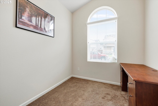 empty room with vaulted ceiling and light carpet