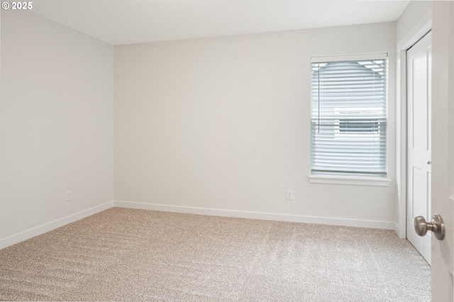 empty room with light colored carpet and baseboards