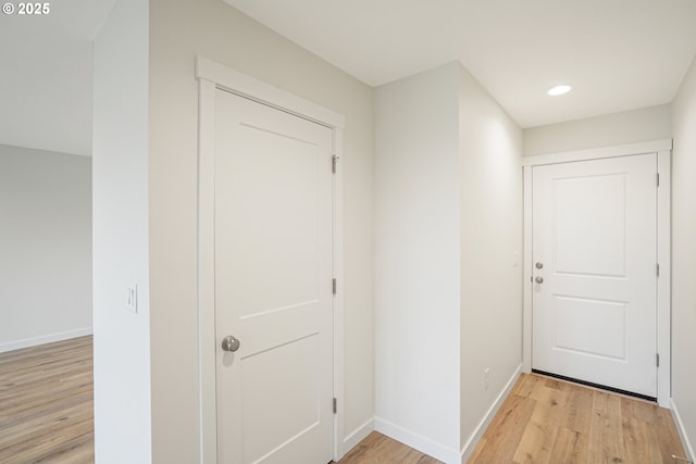 doorway with light wood-type flooring, baseboards, and recessed lighting