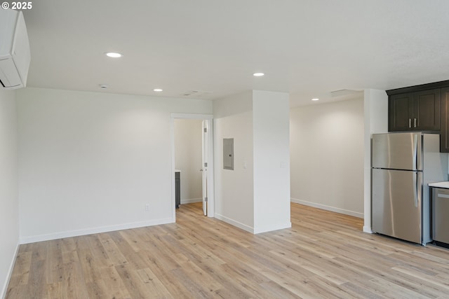 kitchen with freestanding refrigerator, electric panel, light wood-style flooring, and recessed lighting