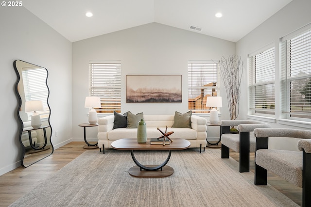 sitting room featuring lofted ceiling, plenty of natural light, visible vents, and wood finished floors