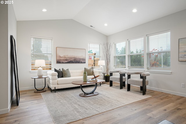 living area with vaulted ceiling, light wood finished floors, visible vents, and recessed lighting