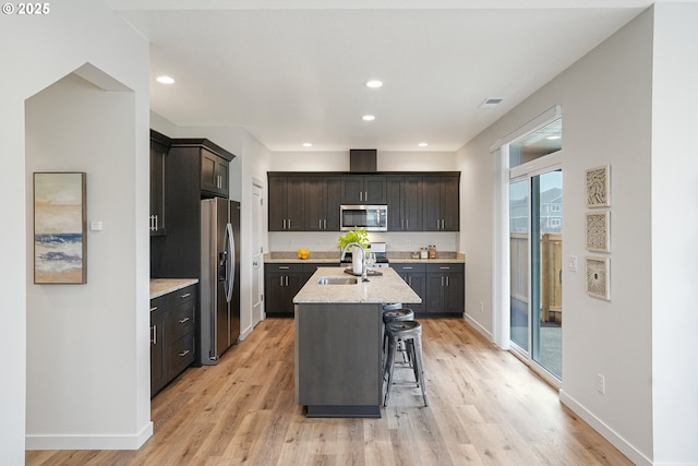 kitchen featuring appliances with stainless steel finishes, light wood-style flooring, a sink, and visible vents