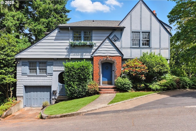 368 NW Lomita Ter, Portland, OR 97210 - tudor-style house with an attached garage, driveway, and roof with shingles