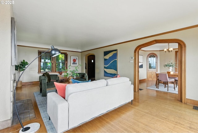 368 NW Lomita Ter, Portland, OR 97210 - living area featuring arched walkways, wood finished floors, healthy amount of natural light, a chandelier, and ornamental molding