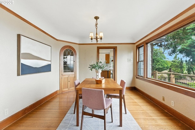 368 NW Lomita Ter, Portland, OR 97210 - dining area with light wood-type flooring, a chandelier, and ornamental molding