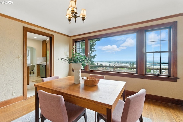368 NW Lomita Ter, Portland, OR 97210 - dining area with a textured wall, light wood-style flooring, and a chandelier