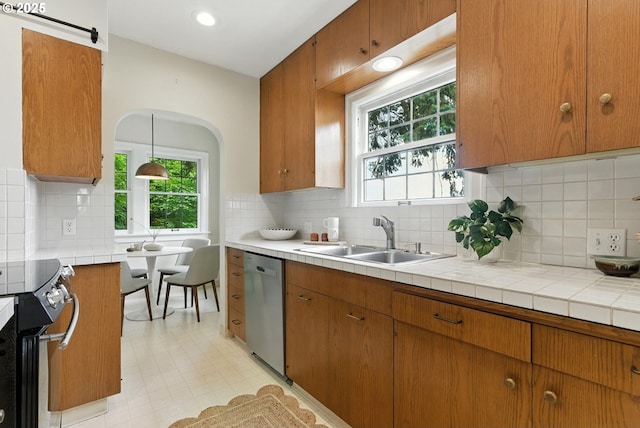 368 NW Lomita Ter, Portland, OR 97210 - kitchen with appliances with stainless steel finishes, backsplash, brown cabinets, light floors, and recessed lighting
