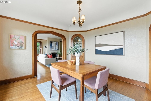 368 NW Lomita Ter, Portland, OR 97210 - dining area with arched walkways, light wood-style floors, a chandelier, ornamental molding, and a textured wall