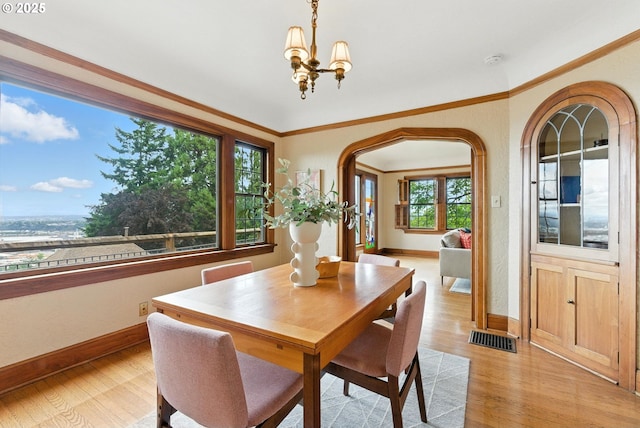 368 NW Lomita Ter, Portland, OR 97210 - dining space with light wood-style floors, arched walkways, and a chandelier