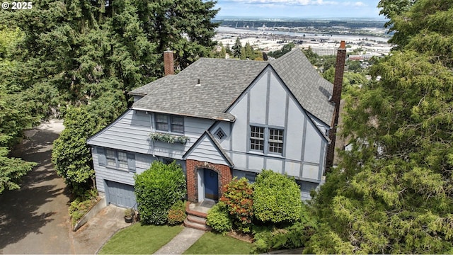 368 NW Lomita Ter, Portland, OR 97210 - english style home featuring roof with shingles, a chimney, a garage, concrete driveway, and stucco siding