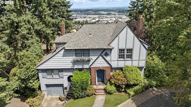 368 NW Lomita Ter, Portland, OR 97210 - tudor home with a shingled roof, a garage, a chimney, and brick siding