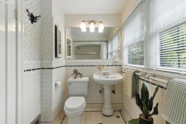 368 NW Lomita Ter, Portland, OR 97210 - bathroom with tile patterned floors, tile walls, wallpapered walls, and wainscoting