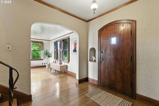368 NW Lomita Ter, Portland, OR 97210 - entrance foyer featuring arched walkways, a textured wall, crown molding, and hardwood / wood-style flooring