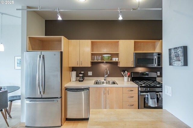 1255 NW 9th Ave Unit 508, Portland, OR 97209 - kitchen with stainless steel appliances, a sink, rail lighting, light brown cabinetry, and open shelves