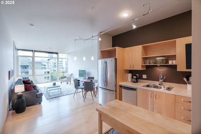 1255 NW 9th Ave Unit 508, Portland, OR 97209 - kitchen with appliances with stainless steel finishes, light brown cabinetry, a sink, open shelves, and expansive windows