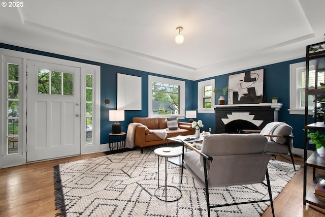 5005 NE Flanders St, Portland, OR 97213 - living room featuring a tray ceiling, wood finished floors, plenty of natural light, and a brick fireplace