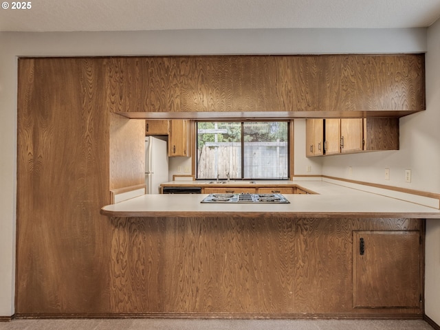 kitchen featuring dishwasher, white fridge, stainless steel gas cooktop, kitchen peninsula, and a textured ceiling